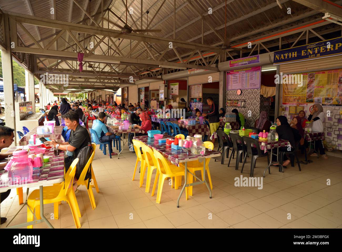 Menschen essen und trinken auf dem Sonntagsmarkt (Pasar Tani Kekal Tamu) in Kota Belud, Sabah, Borneo, Malaysia. Stockfoto