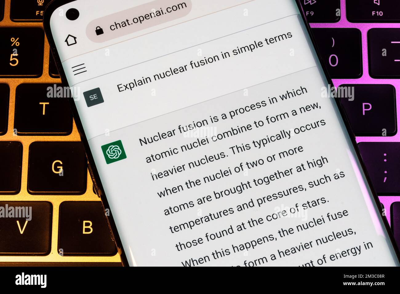 ÖFFNEN Sie den AI-ChatGPT-Chat-bot, der auf einem Smartphone auf einem Laptop angezeigt wird. KI-Chatbot antwortete auf die Frage zur Kernfusion. Stafford, Großbritannien, Dez. Stockfoto