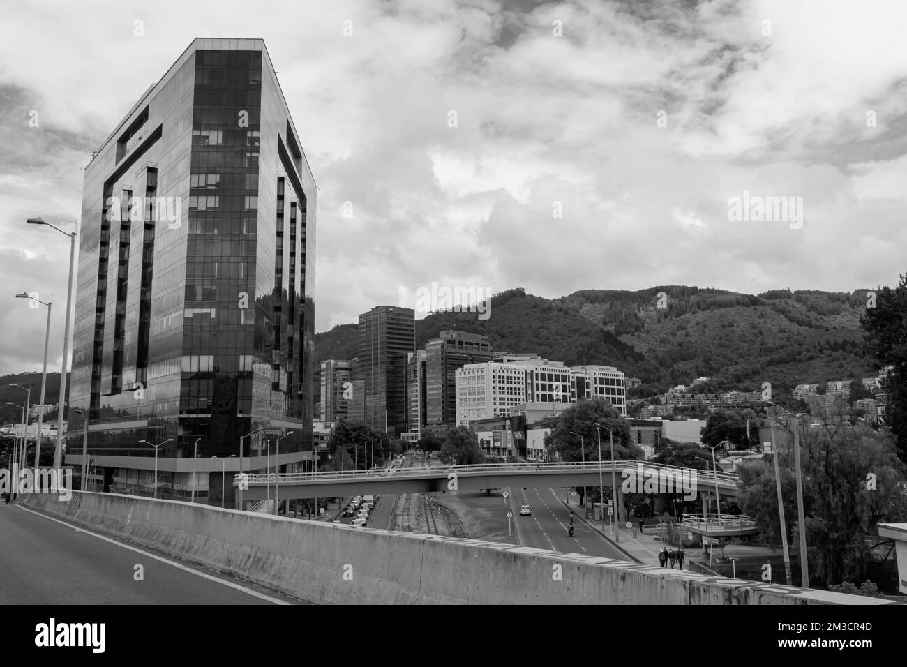 Schwarzweiß-Fotoszene in Bogota mit modernen Gebäuden und Bergen im Hintergrund. Modernes Architekturdesign Stockfoto