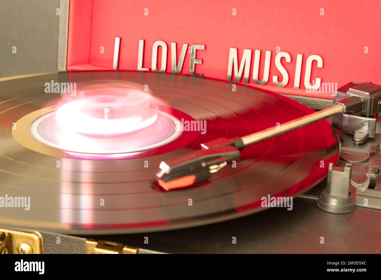Nahaufnahme einer Drehtischkanüle, die eine LP-Vinyl-Disc mit Drehtisch spielt, und ich liebe die Beschriftung auf rotem Hintergrund. Konzept für Musikliebhaber. Stockfoto