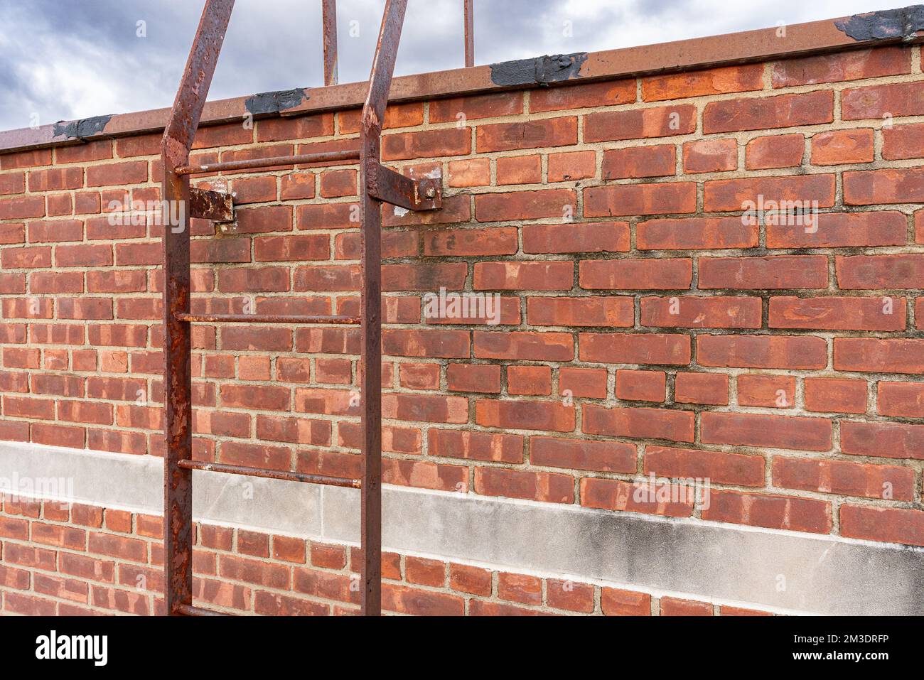Altes industrielles Ziegelgebäude mit Dachleiter aus Metall. Stockfoto