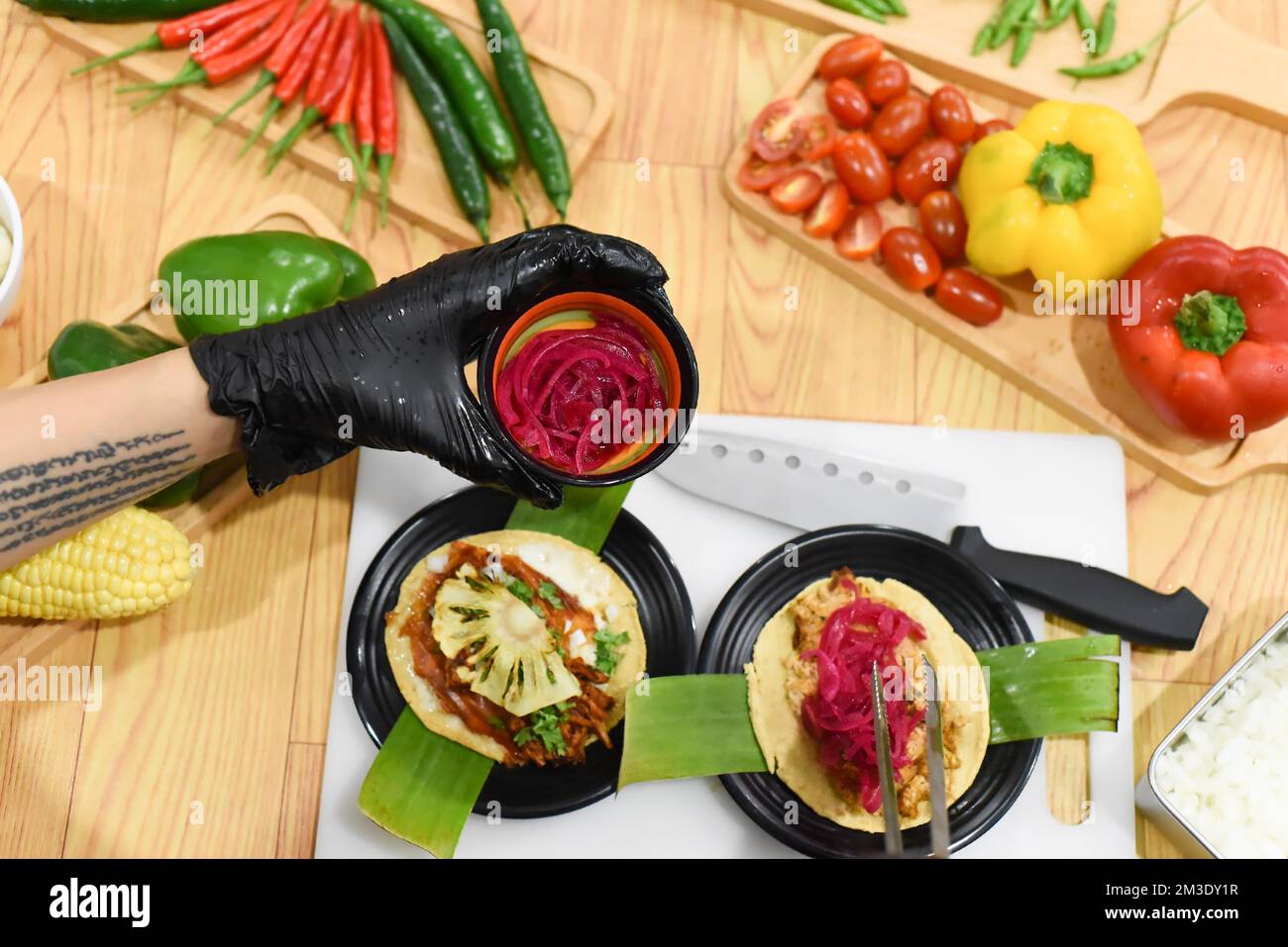 Rosa Zwiebel mariniert mit Rote Bete in der Hand für die Zubereitung von Tacos in einem mexikanischen Restaurant Stockfoto