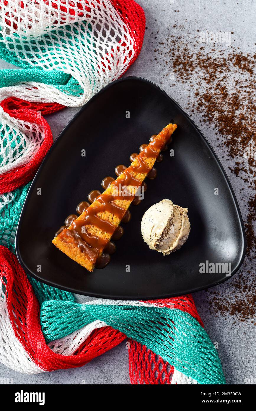 Tlatelolco Maisbrotkuchen Kaffeesahne auf schwarzem Teller mit mexikanischer Dekoration Stockfoto