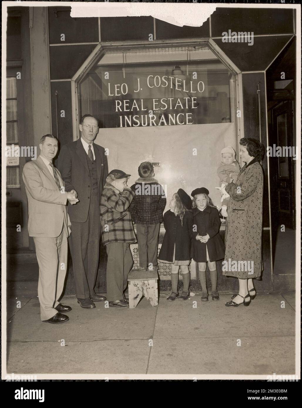 Leo J. Costello schüttelt die Hand von Thomas F. Hughes, der Familie