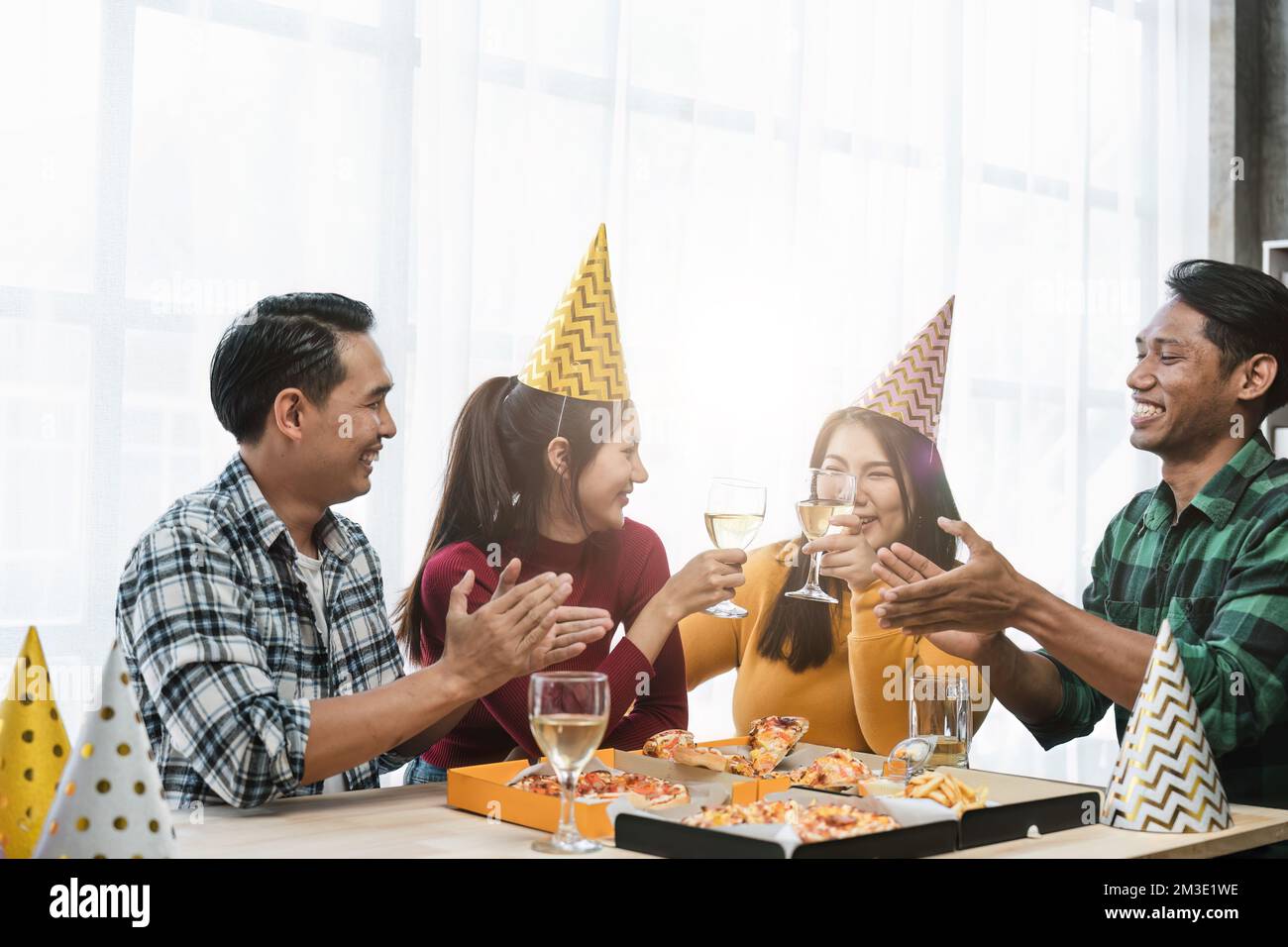 Gruppe glücklicher Kollegen, die Spaß bei einer bevorstehenden Neujahrsfeier oder Geschäftserfolg haben. Kollegen mit unterschiedlichen ethnischen Zugehörigkeiten toasten Wein oder Stockfoto