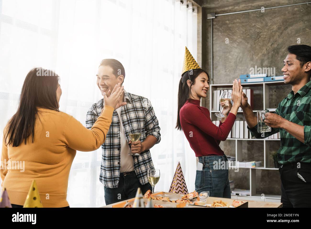 Gruppe glücklicher Kollegen, die Spaß bei einer Neujahrsfeier oder einem Geschäftserfolg haben. Kollegen mit unterschiedlichen Personen auf der Party im Büro Stockfoto