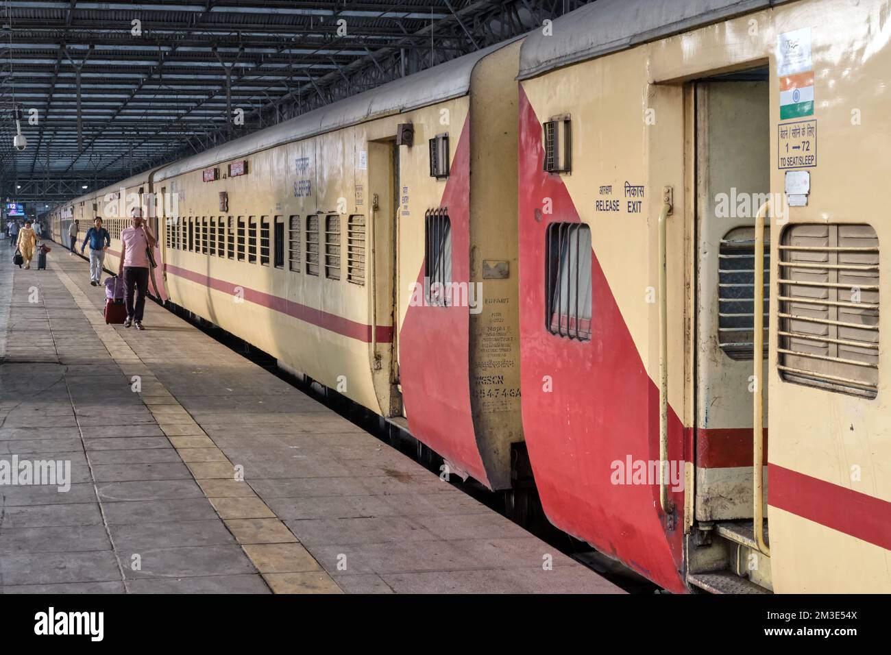 Eisenbahnpassagiere, die an den Waggons eines Fernzugs am Chhatrapati Shivaji Maharaj Terminus in Mumbai, Indien vorbeifahren Stockfoto