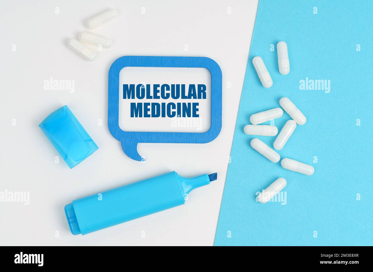 Medizin und Gesundheitskonzept. Auf einem weißen und blauen Tisch befinden sich Pillen, ein Marker und eine blaue Plakette mit der Aufschrift "Molekulare Medizin" Stockfoto
