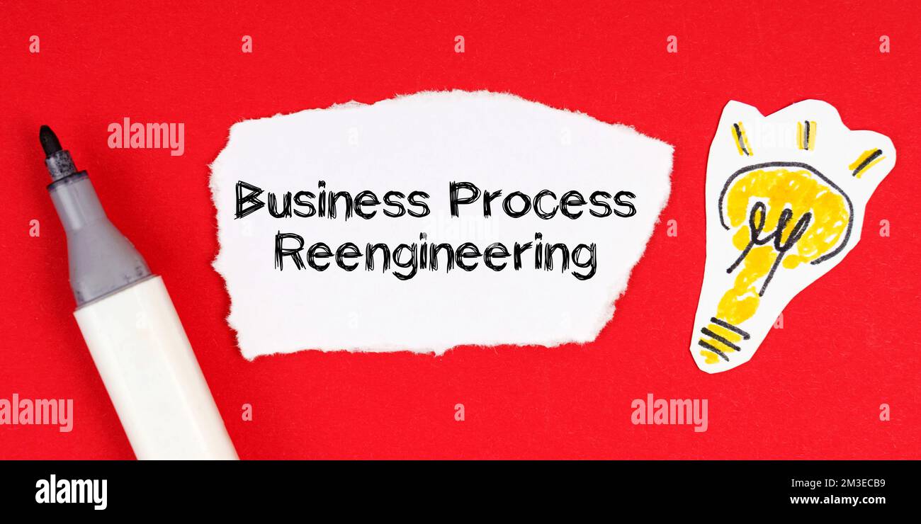 Geschäftskonzept und -Idee. Legen Sie auf einer roten Oberfläche einen Marker, eine Zeichnung einer Glühbirne und ein zerrissenes Papier mit der Aufschrift „Business Process Reengineering“ Stockfoto