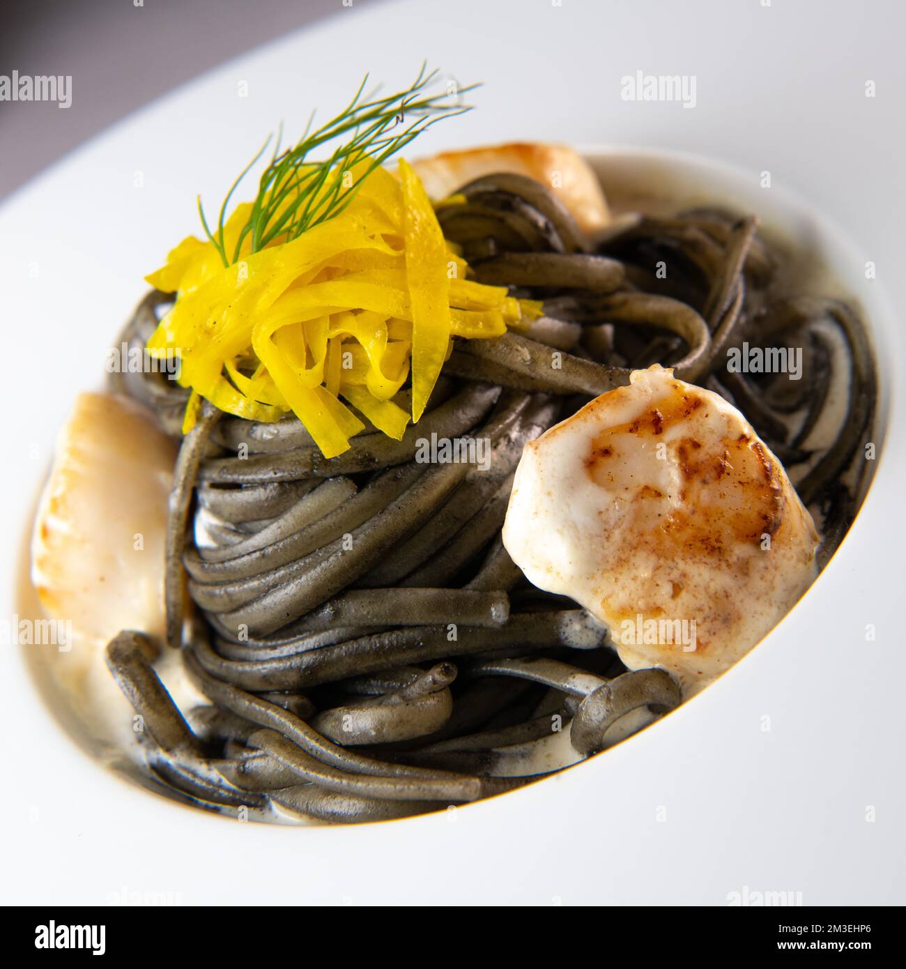 Rezept für Linguine Pasta mit Tintenfischtinte und Jakobsmuscheln, gelbe chioggia-Beete Stockfoto