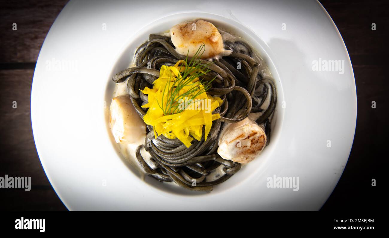 Rezept für Linguine Pasta mit Tintenfischtinte und Jakobsmuscheln, gelbe chioggia-Beete Stockfoto