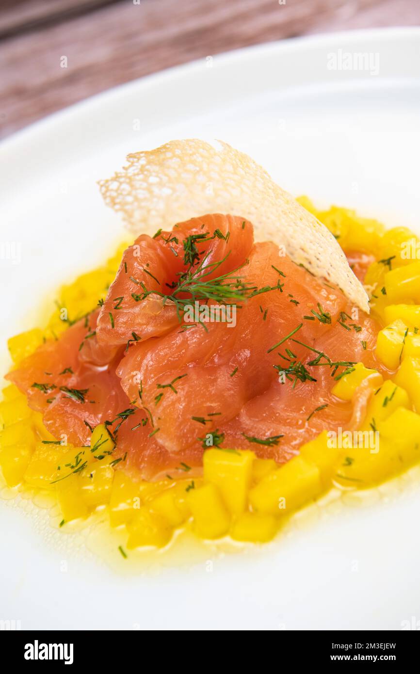 Rezept für Lachs-Gravlax mit Mango-Brumoise und weißem Balsamico-Essig-Dressing Stockfoto