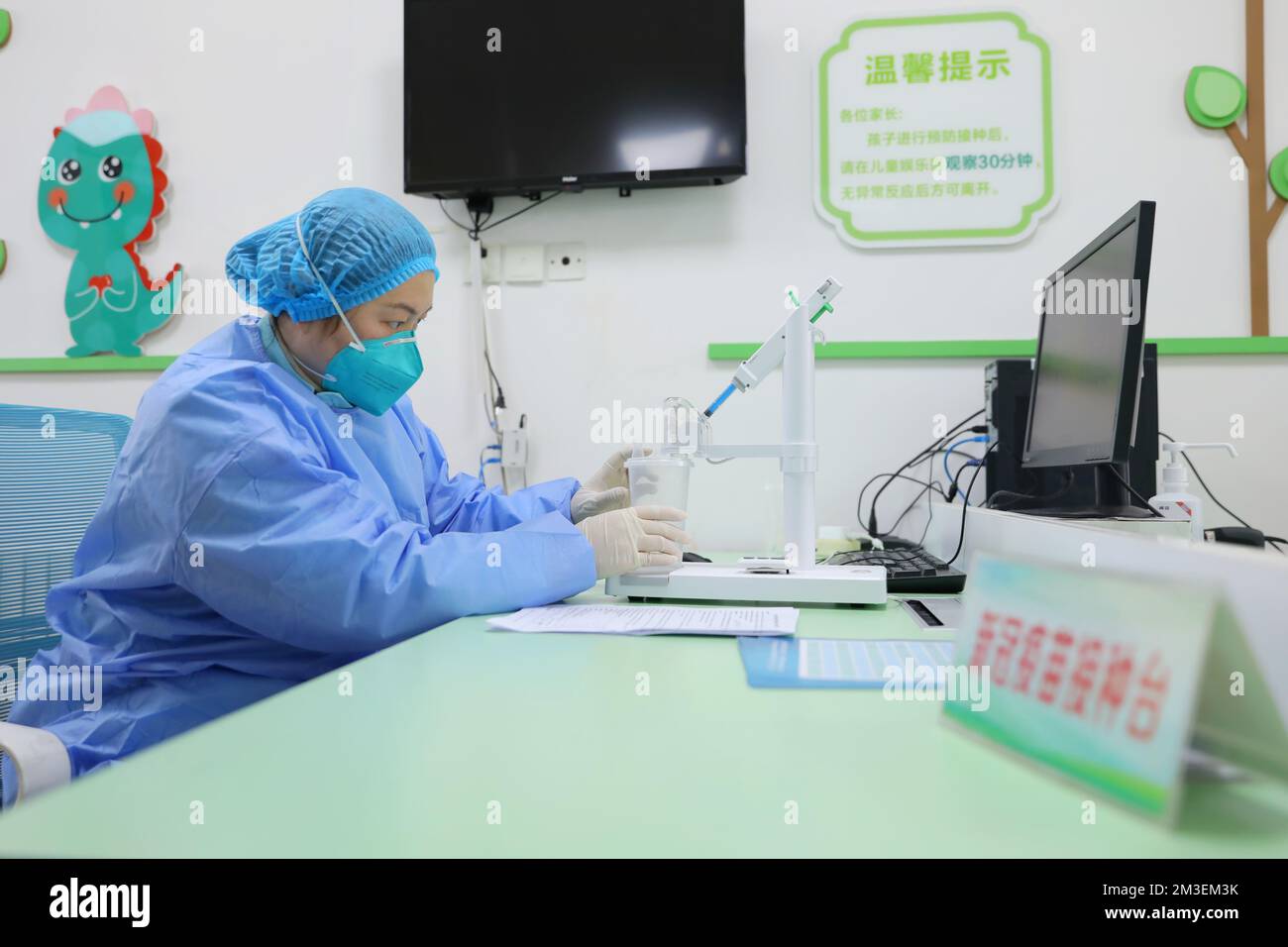 QINGDAO, CHINA - 15. DEZEMBER 2022 - Ein Mitarbeiter Injizierte inhalativen COVID-19-Impfstoff in einen zerstäubten Becher in einem gemeinnützigen Gesundheitszentrum in Qingdao, EAS Stockfoto