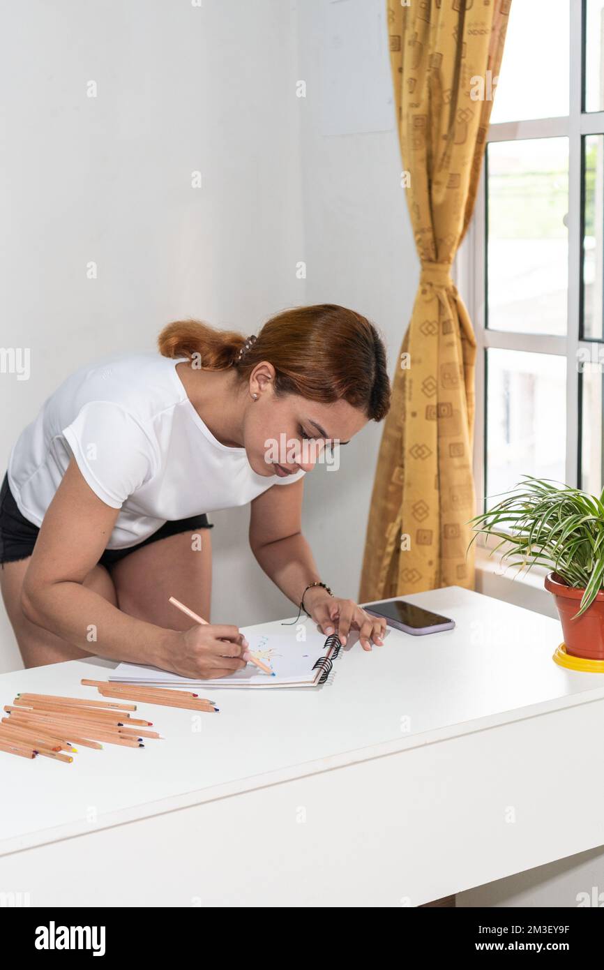 Künstlerin Woman zeichnet im Skizzenbuch Stockfoto