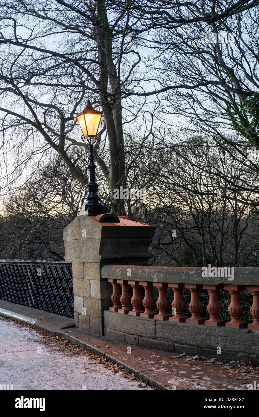 Eine viktorianische Lampe an der Armstrong Bridge, Jesmond Dene, in Jesmond, Newcastle upon Tyne, Vereinigtes Königreich, An einem späten Nachmittag im Winter. Stockfoto