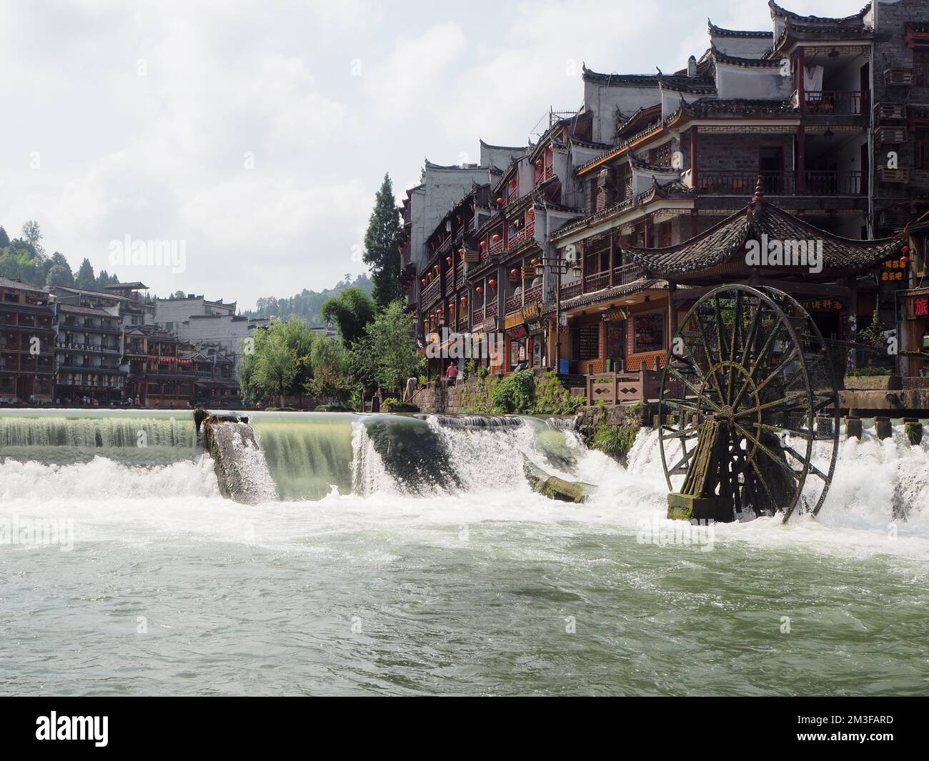 Wasserfall und Wassermühle im Fluss durch die antike Stadt Fenghuang in China Stockfoto