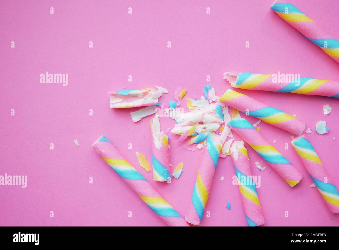 Bunte Waferrolle Schokolade auf rosa Hintergrund Stockfoto