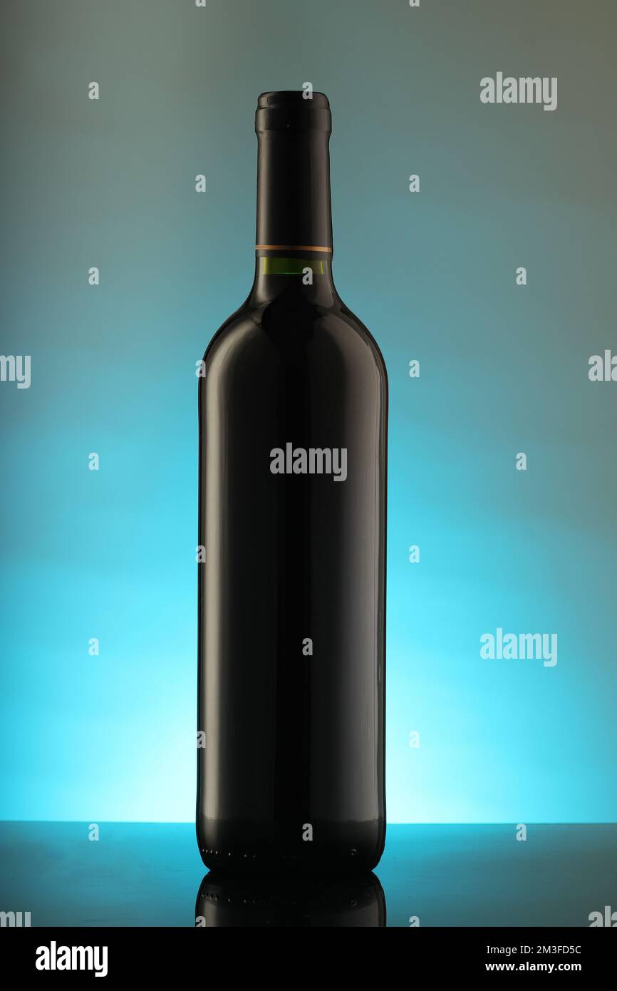 Flasche Rotwein auf blauem Hintergrund Stockfoto