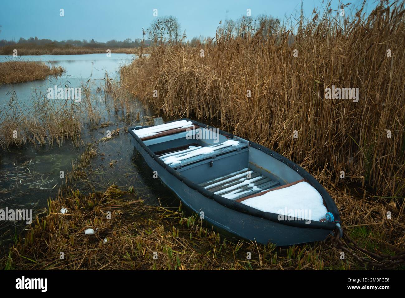 Ein kleines Boot am Ufer eines gefrorenen Sees, Ostpolen Stockfoto