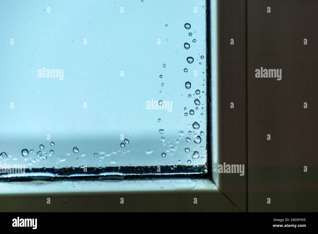 Wassertropfen auf dem Glas in der Ecke des Fensters, Winterblick Stockfoto