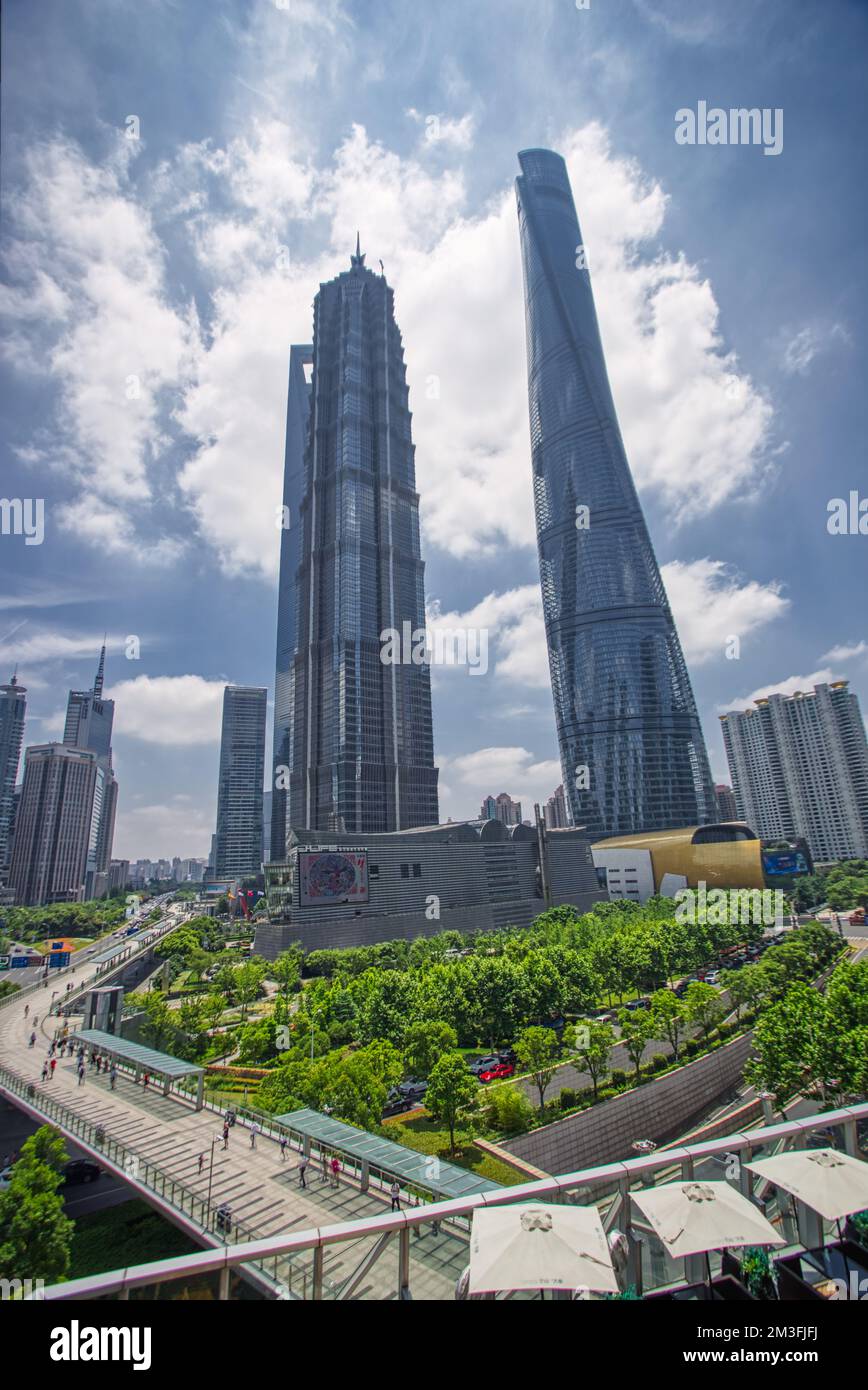 Shanghai World Financial Center, Shanghai Tower, Jin Mao Tower und urbaner Dschungel fotografiert von unten im Sommer vor blauem Himmel und Wolken Stockfoto