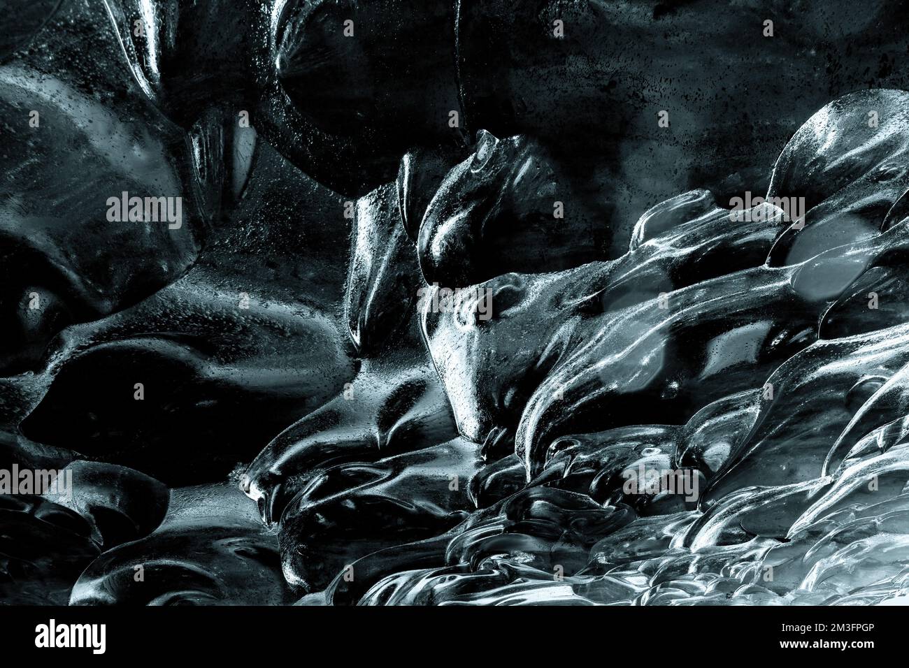 Gletschereis abstrakter Hintergrund. Details des geschwungenen blauen Eis einer Eishöhle im Süden Islands. Stockfoto