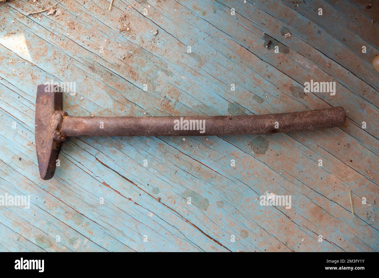 Ein alter Spitzen-Hammer auf einem blauen Holzboden Stockfoto