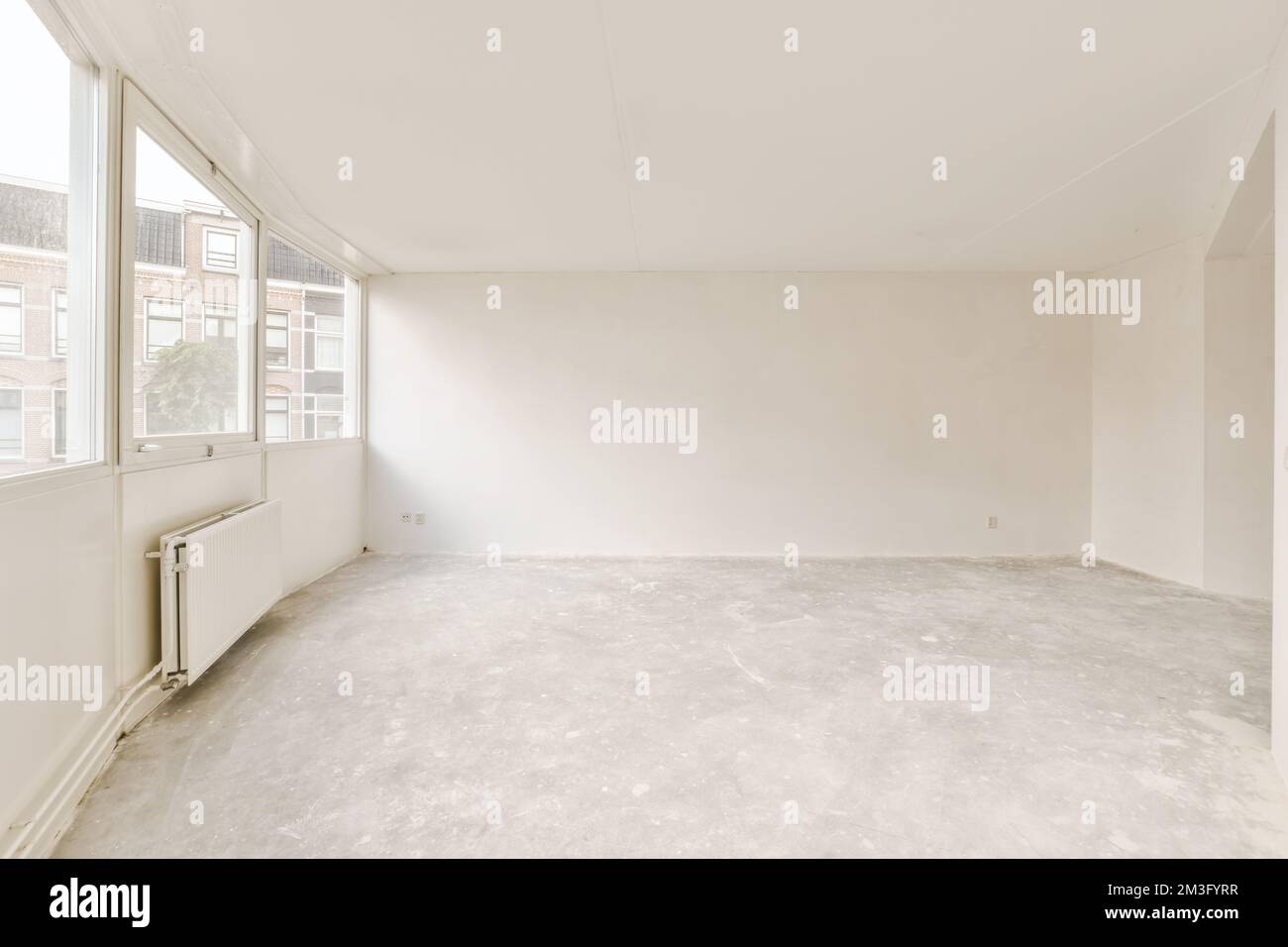 Ein leerer Raum, in dem niemand auf dem Boden und die Fenster auf dem Foto stehen, wird herausgenommen, um zu zeigen, wie es läuft Stockfoto