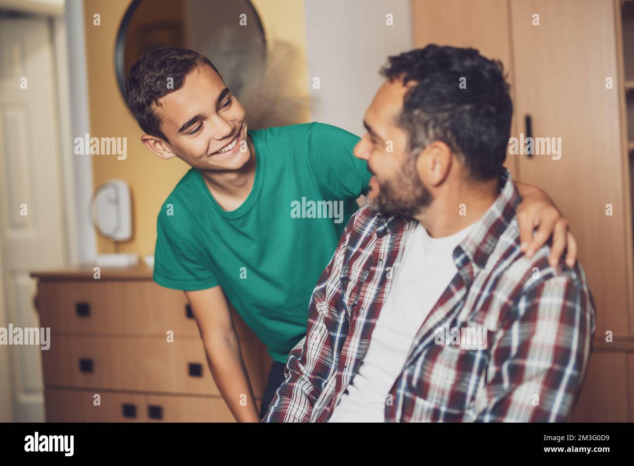 Porträt von glücklichem Vater und Sohn zu Hause. Sie umarmen sich. Stockfoto
