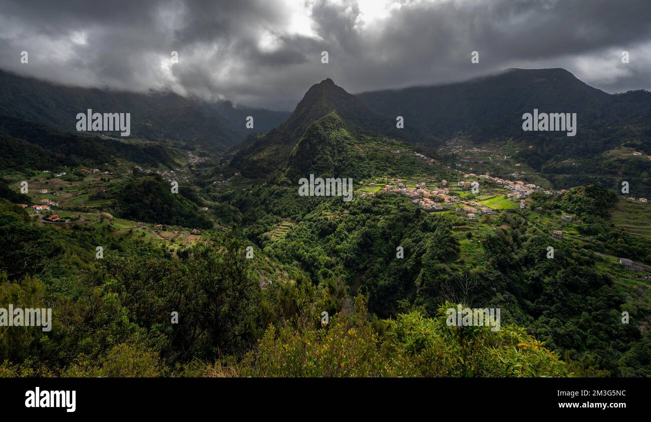 Kamm von Pico do Alto, Blick auf bewaldete, wolkenbedeckte Berge mit dem Dorf Boaventura, Madeira, Portugal Stockfoto