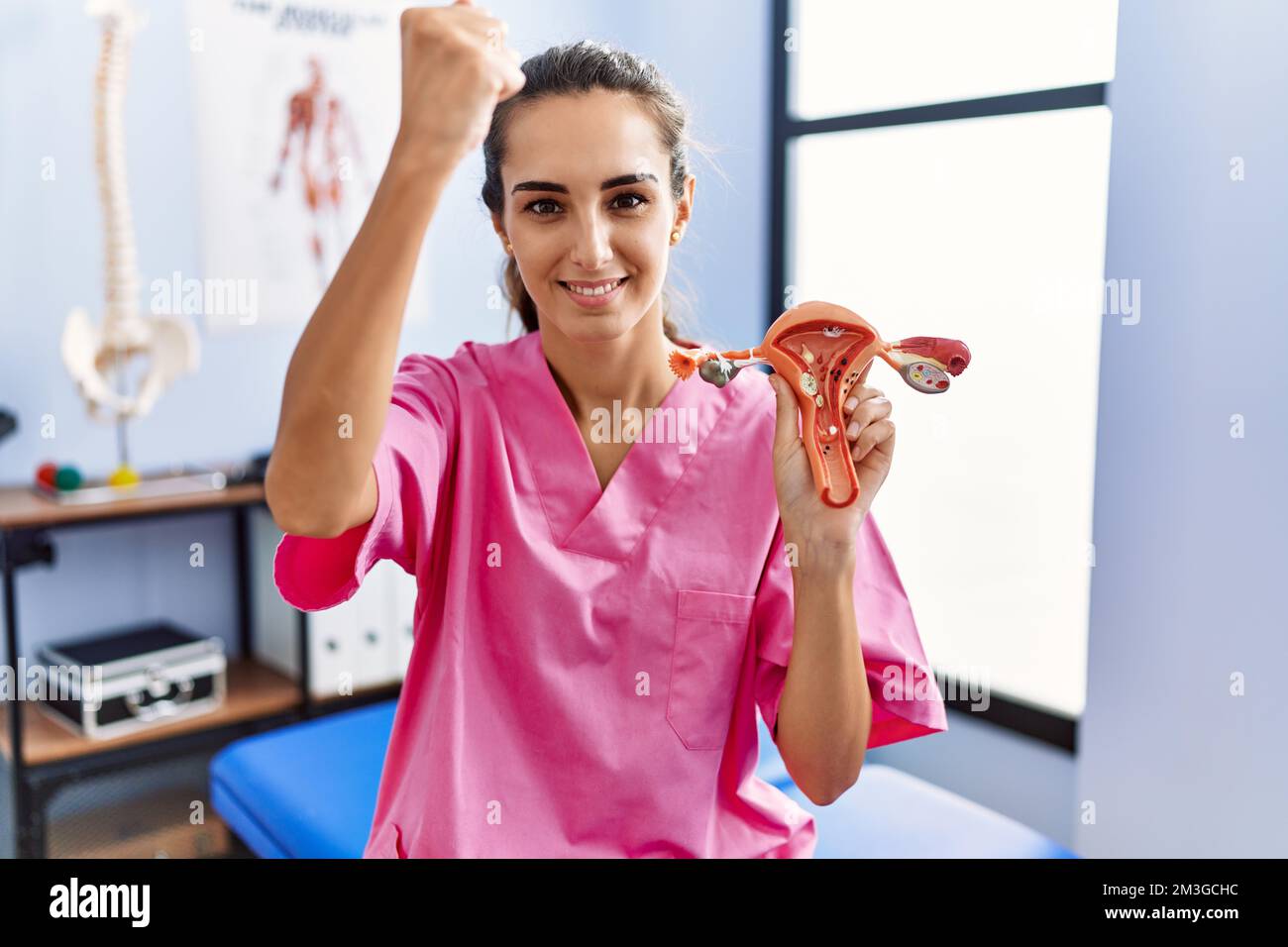 Li Chen Ang Junge hispanische Frau, die ein Modell des weiblichen Genitalorgans in ...