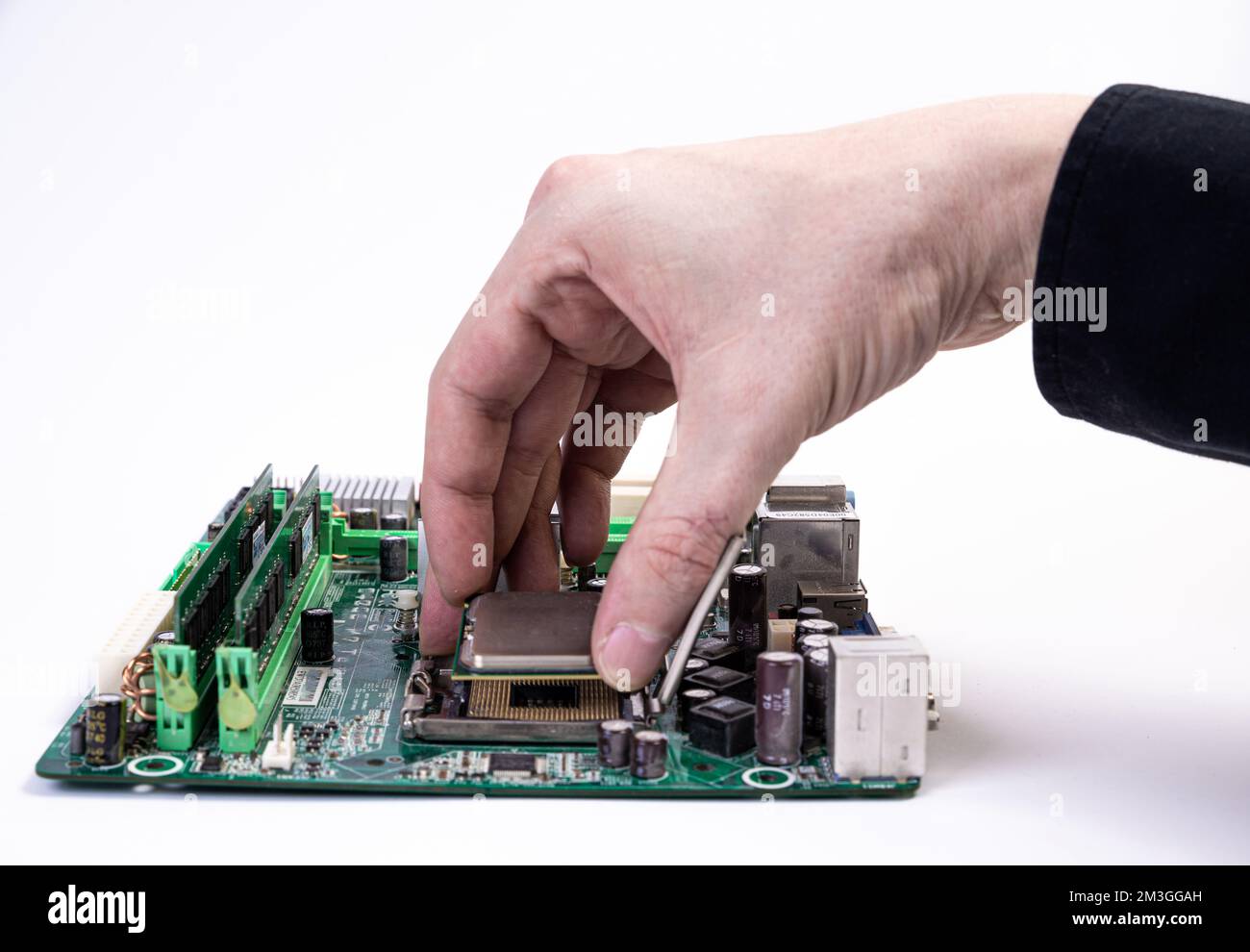 Ingenieur Mechaniker Hände halten in schwarz Handschuhe, Prozessor, CPU in den Sockel des computer Motherboard zu stecken. Das Konzept der Technologie Stockfoto