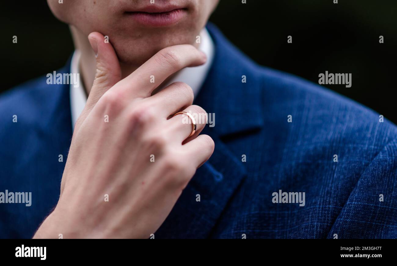 Eleganter Mann, der seine Krawatte über schwarzem Hemd bindet. Kabelbinder einstellen. Schwarz und Violett. Junger Geschäftsmann im Kostüm, isoliert auf schwarzem Hintergrund. Der Bräutigam passt sich an Stockfoto