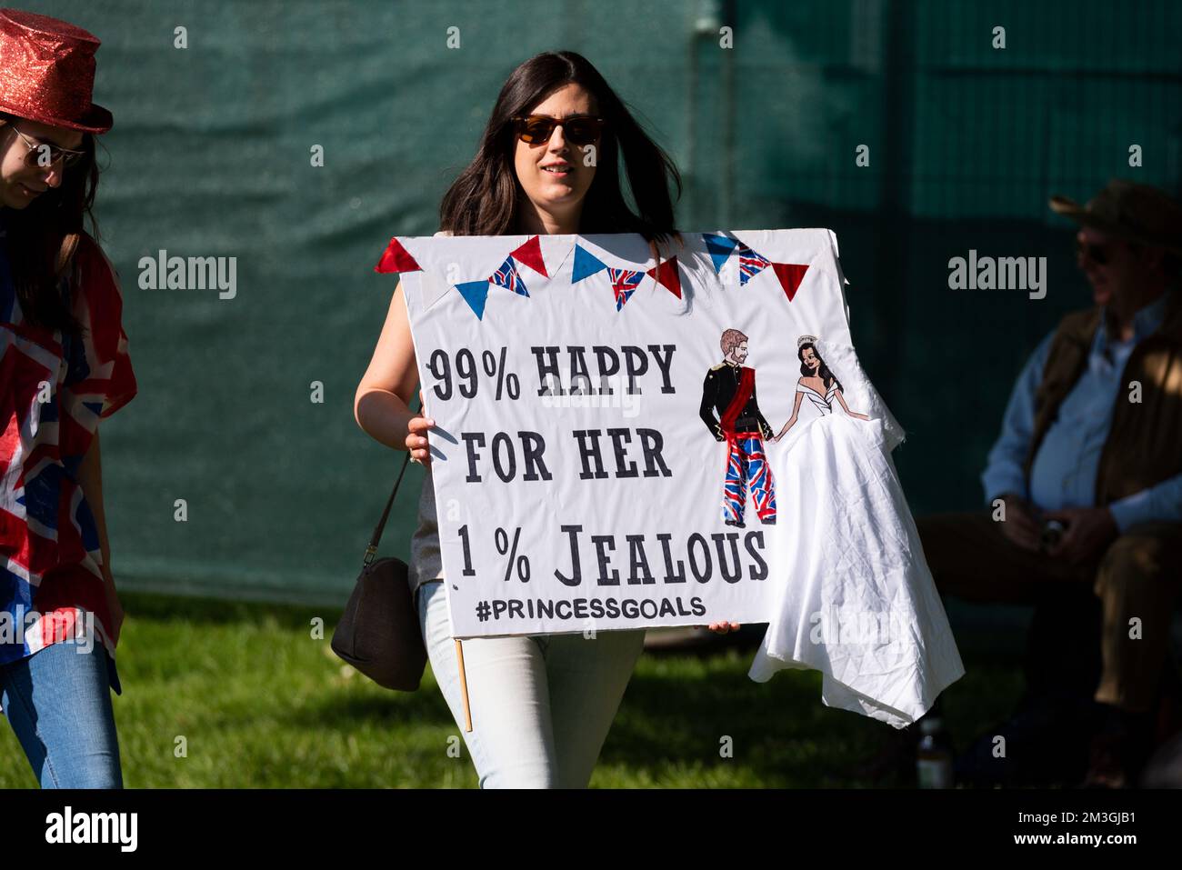 Frau mit Prinzessinnen-Toren-Plakat bei der königlichen Hochzeit von Prinz Harry und Meghan Markle in Windsor. Glücklich und eifersüchtig. Hochzeitskleid-Design Stockfoto