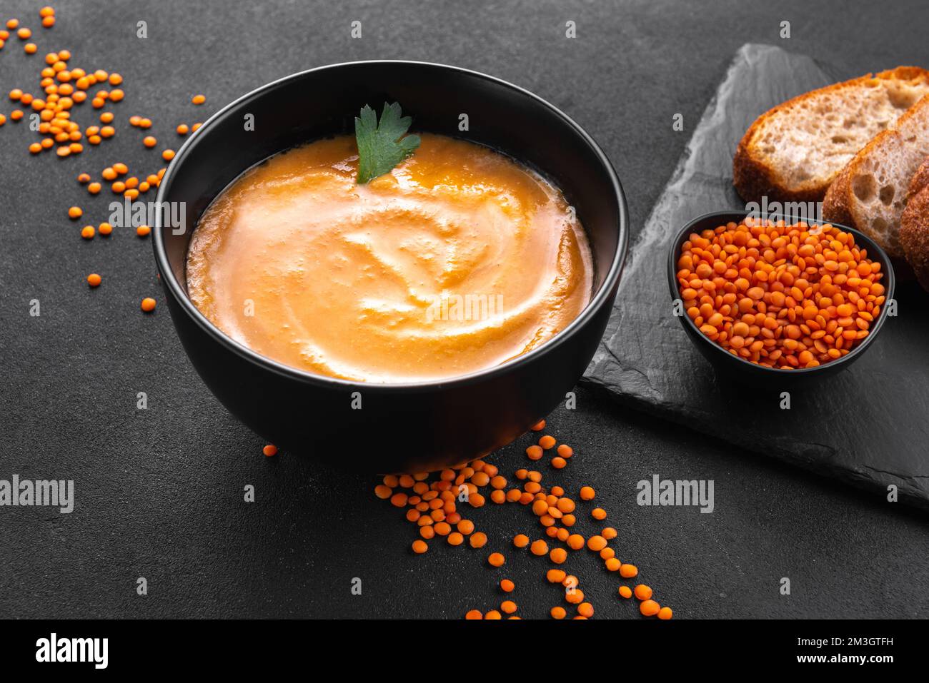 Rote Linsensuppe auf dunklem Hintergrund, Draufsicht. Traditionelle nahöstliche, türkische und Ramadan-Küche. Vegane Küche. Vegetarische Lebensmittel gesunde Lebensmittel. Rot Stockfoto