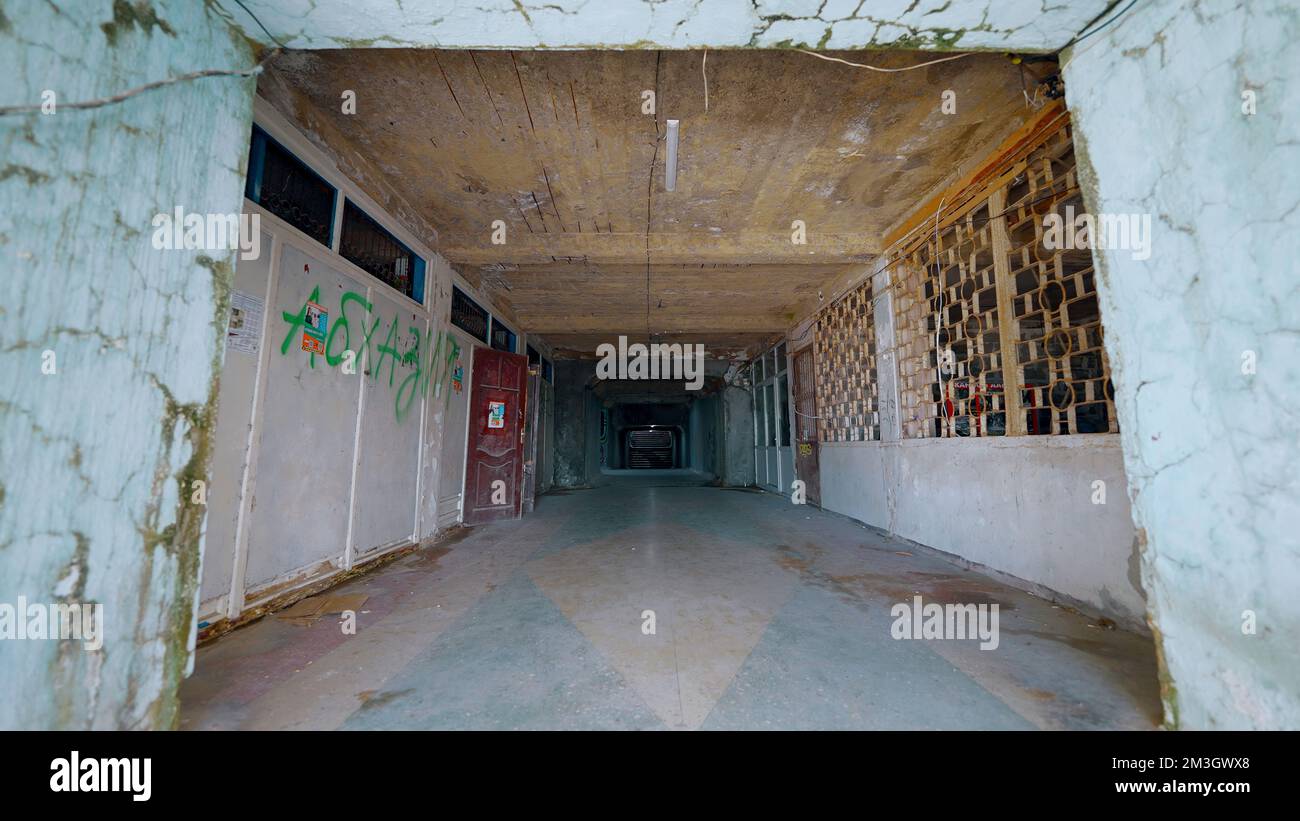 Korridor eines verlassenen Gebäudes. Aktion. Altes, bröckelndes Gebäude mit Flur und Blitzlampe. Verlassenes Gebäude mit Lobby. Stockfoto