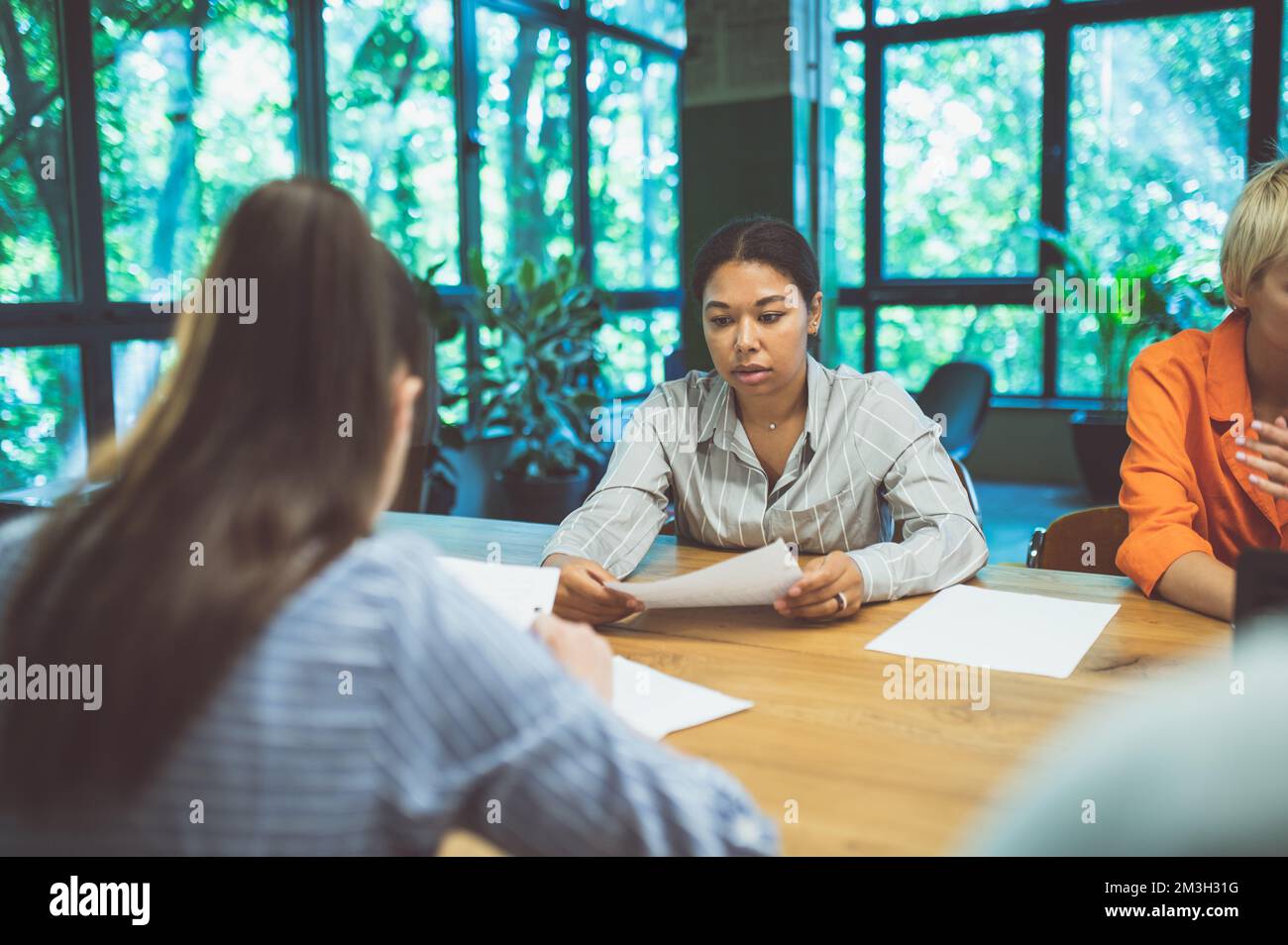 Filmbild von Menschen, die in einem Start-up-Unternehmen arbeiten. Multiethnisches Expertenteam, das bei der Entwicklung der neuen Projekte zusammenarbeitet Stockfoto