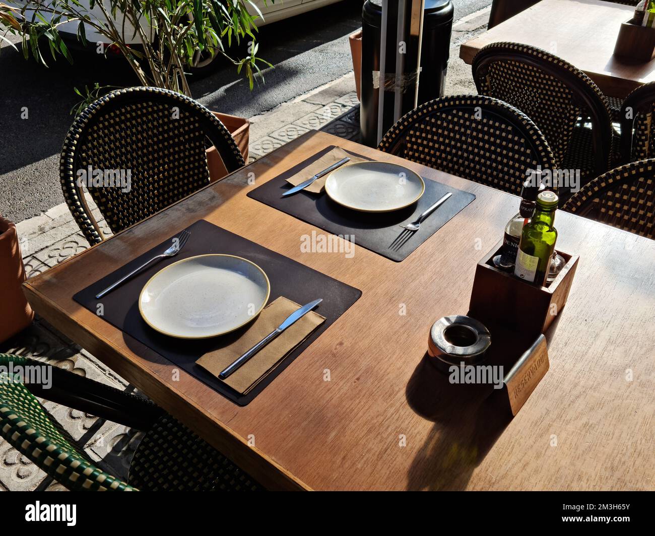 Restaurant im Freien. Tisch mit Geschirr, Besteck, Öl und Essig für zwei Personen. Barcelona, Katalonien, Spanien. Stockfoto