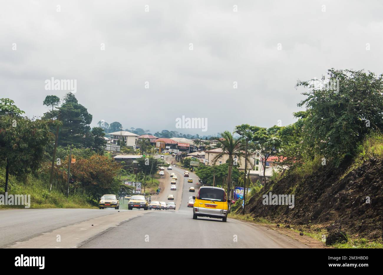 Straßen von Kamerun, Südwestregion, so genanntes Ambazonia Land mit viel Verkehr und Menschen, die in Eile vorbeifahren Stockfoto