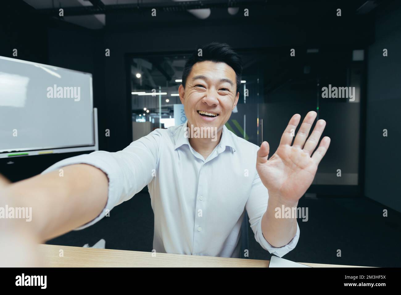 Porträt eines jungen, gutaussehenden Asiaten, der ein Selfie macht, ein Video aufnimmt, bei einem Videoanruf spricht, ein Telefon hält, die Kamera winkt und grüßt, lächelt. Stockfoto