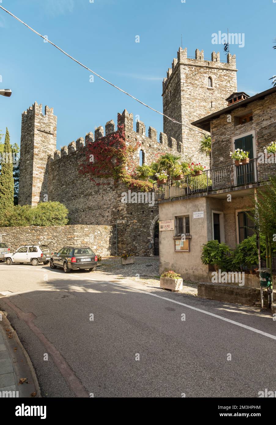 Rezzonico, San Siro, Lombardei, Italien - 18. Oktober 2022: Straße im Dorf San Siro mit mittelalterlicher Burg Rezzonico am Ufer des Sees Stockfoto