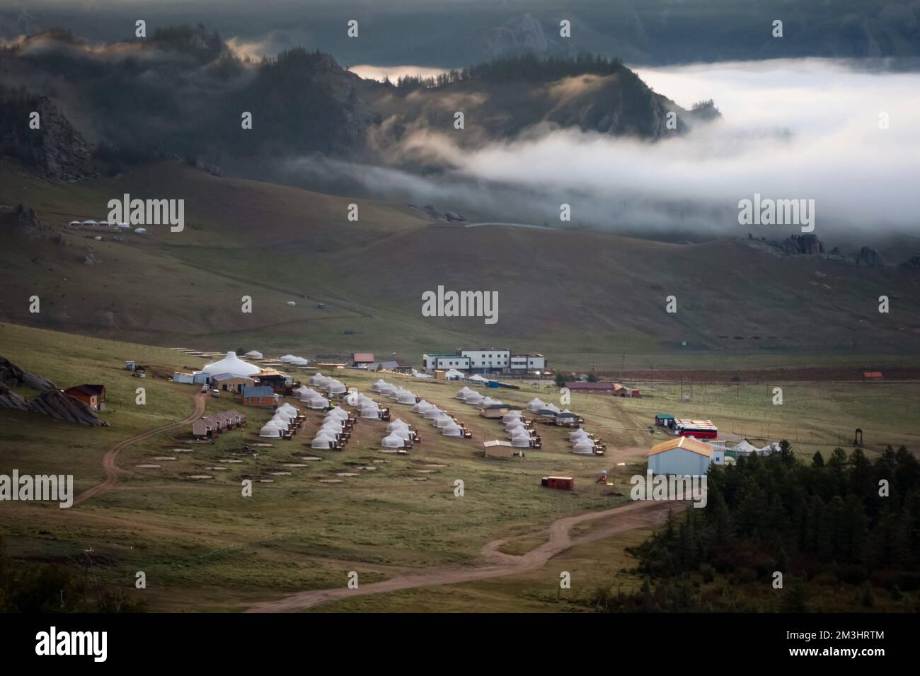 Winzige Häuser, umgeben von Bäumen auf dem Bergrücken. An einem sonnigen Tag auf dem Hügelkamm kleine Ger-Hütten. Stockfoto