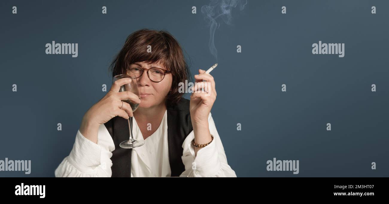 Eine Frau in einem Drama mit Alkohol und einer Zigarette. Retro-Porträt. Frau Autorin der Vergangenheit. Stockfoto
