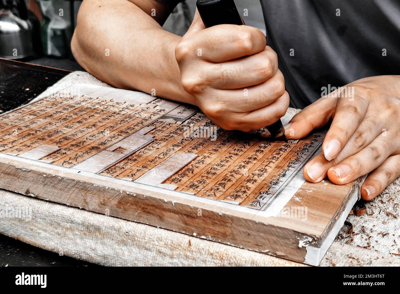 Eine Nahaufnahme von erwachsenen Händen, die den traditionellen chinesischen Holzblockdruck machen Stockfoto