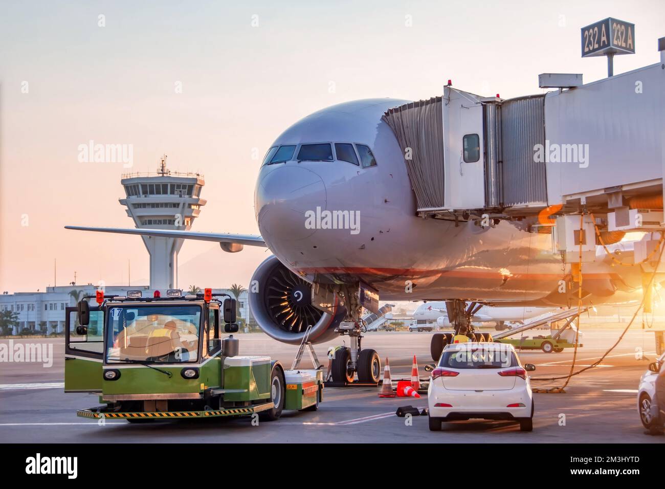 Die Flugzeuge werden von Flugplatzdiensten an der Gangway des Flughafenterminals gewartet, um das Abschleppen und den Start in den Flug vorzubereiten Stockfoto