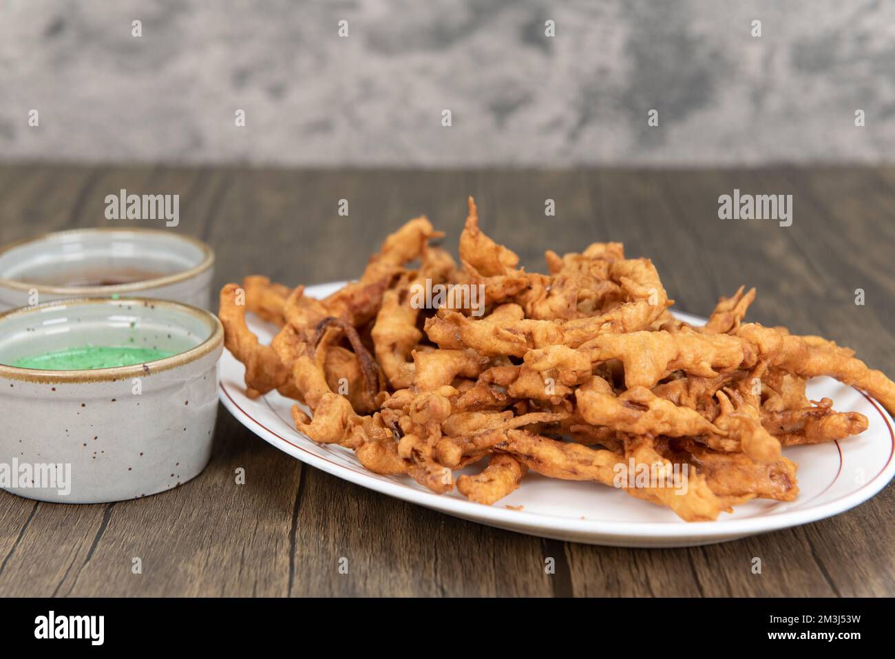 Frittierte knusprige Vorspeise mit Zwiebeln bahji, serviert mit Humus und Dip-Sauce. Stockfoto