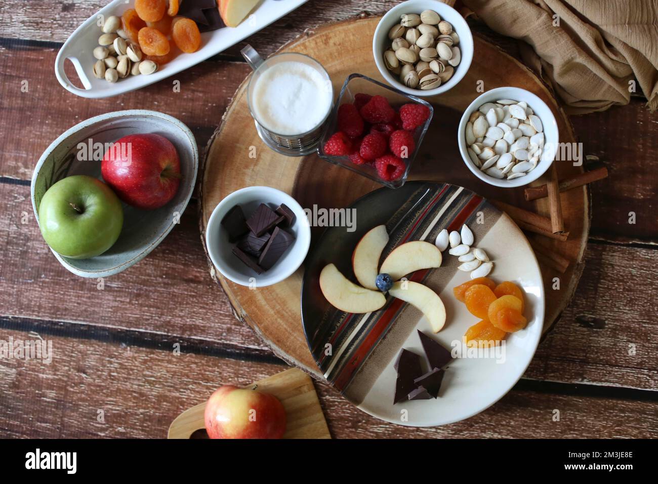 Flache Aufnahme von Wurstplatte mit Früchten und Nüssen, brauner Hintergrund Stockfoto