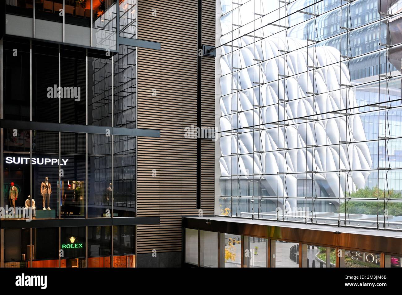 NEW YORK - 24. Okt 2022: Innenbereich der Shops und Restaurants in Hudson Yards, der Schuppen ist durch das Frontfenster sichtbar. Stockfoto