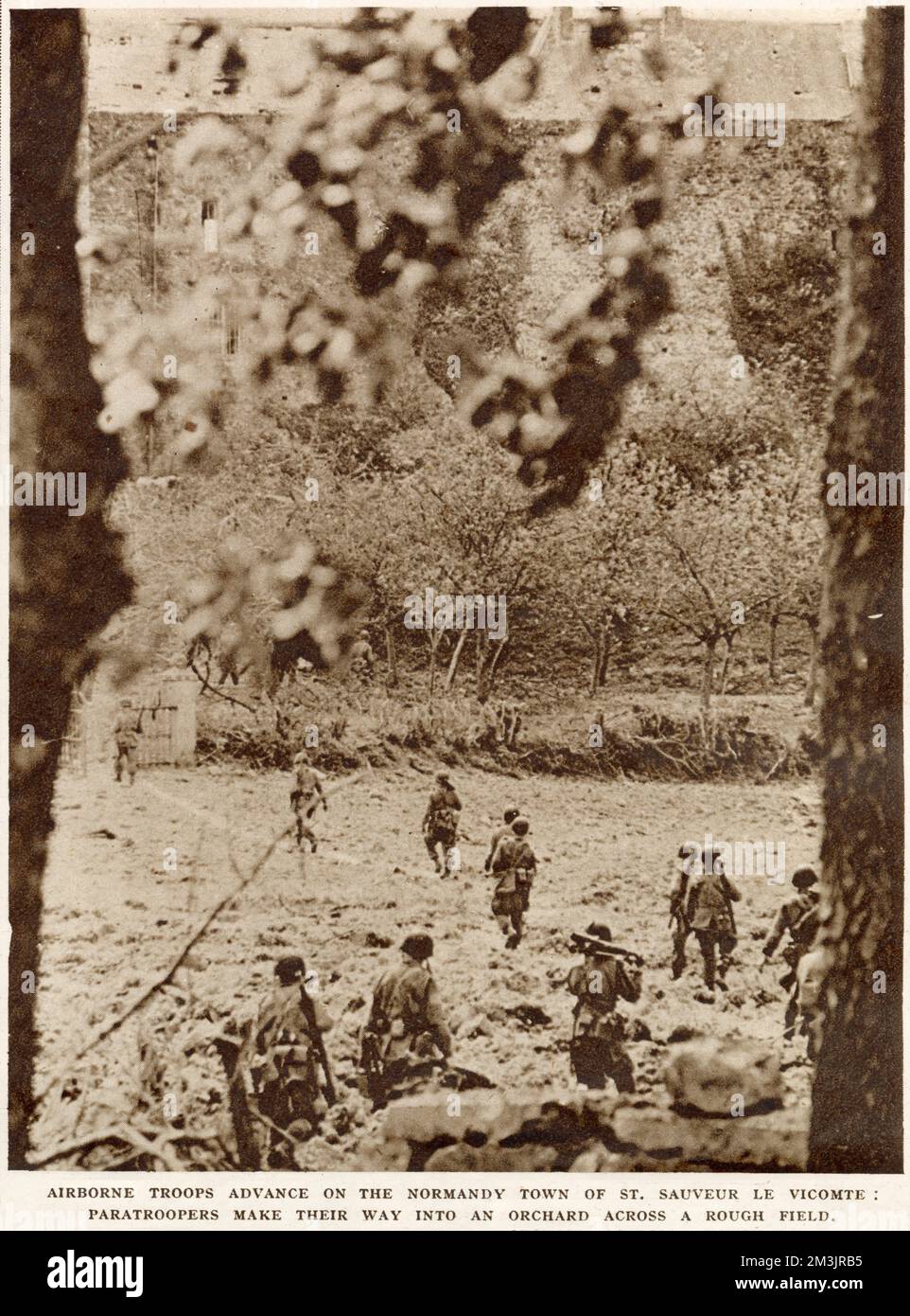 Amerikanische Luftstreitkräfte, die durch einen Obstgarten in die Stadt St. vorrücken Sauveur Le Viconte, Normandie, Juni 1944. Dieses Foto wurde kurz nach dem "D-Day", dem 6. Juni, aufgenommen, als die Fallschirmjäger nach Frankreich abgeworfen wurden. Stockfoto