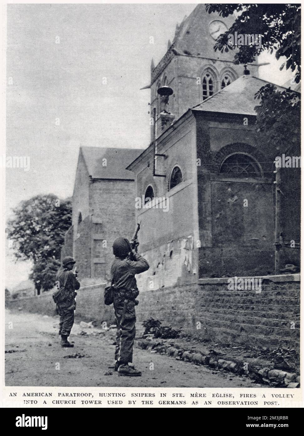 Amerikanische Fallschirmjäger, Scharfschützen in St. Nur Eglise, die eine Volleyfahrt in einen Kirchenturm abfeuert, der von deutschen Soldaten als Beobachtungsposten benutzt wird. Das Foto wurde in der Kampfzone der Normandie aufgenommen, kurz nach der Landung am D-Day am 6. Juni 1944. Stockfoto